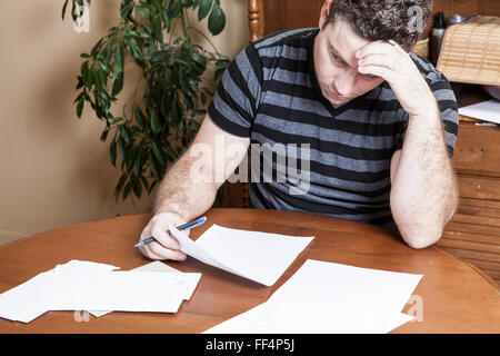 Frustrated man sits in the kitchen Stock Photo
