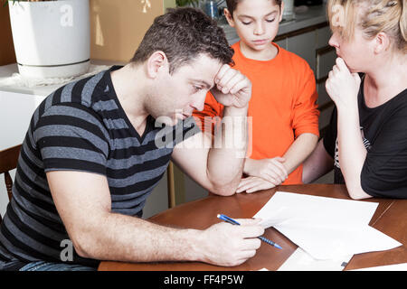 young woman with her husband calculate home budget in the kitchen Stock Photo