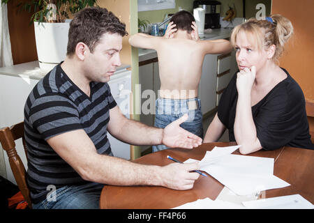 young woman with her husband calculate home budget in the kitchen Stock Photo