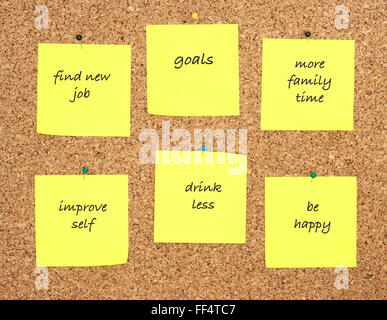 Goals for new year written on yellow sticker notes over cork board background Stock Photo
