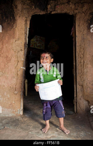 A young boy from the Dobhanda Nagar slum in Cuttack gets her birth certificates from the Urban Law centre run by the organisation CLAP. Committee for Legal Aid to Poor (CLAP) helps provide legal aid to the poorer communities in the Orissa district of India. Stock Photo