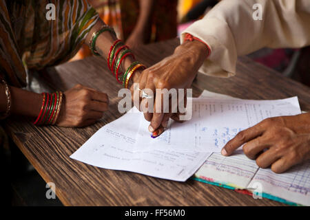 Signing the paper work. A woman from a rural slum in the Orissa district of India gets legal advice and birth certificates from a Legal Aid Clinic run by the organisation CLAP. Committee for Legal Aid to Poor (CLAP) is a non-profit organisation helping to provide legal aid to the poorer communities in the Orissa district of India. Stock Photo