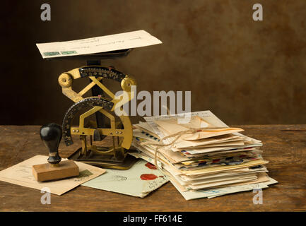 Antique letter scale on an old wooden table with a bundle of letters Stock Photo