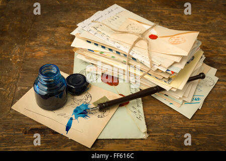 Vintage ink well and fountain pen on a table with old letters Stock Photo