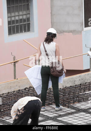 Woman holiding plans on construction site. Stock Photo