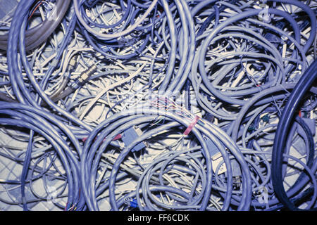 A mass of coiled and tangled computer and electrical cables. Stock Photo