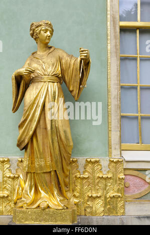 Gilded sandstone statue of a woman playing the triangle, Chinese House, Sanssouci Park, Potsdam, Germany Stock Photo