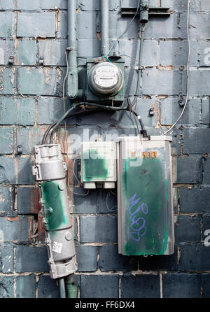 Cable boxes and electric meter on a brick wall in Seattle. Stock Photo