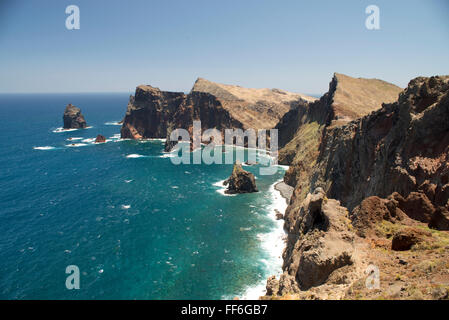 Cliffs and rock faces at the hills of the windswept Eastern Cape of Madeira near Ponta de Sao Lourenco with a deep blue sea Stock Photo