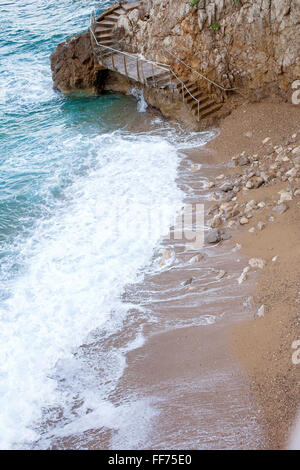 Staircase on a little beach around a steep rock wall, connecting two beaches on the Mediterranean Sea, Monte Carlo, Monaco Stock Photo