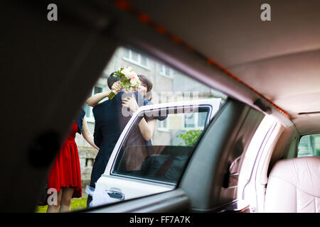 Embracing view of the newlyweds through a car door Stock Photo