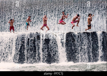 Boys jumping in a waterfall and having fun, Bali, Indonesia Stock Photo