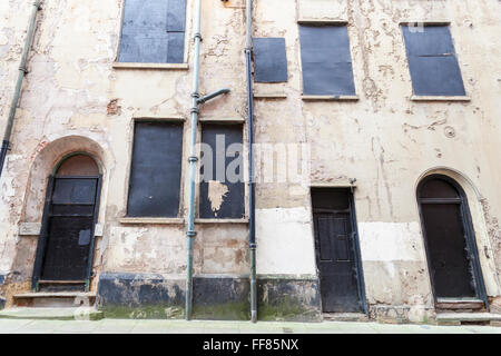Wall and boarded up windows and doors on a neglected 17th century town house that has been left to fall into disrepair, Pilcher Gate, Nottingham, UK Stock Photo