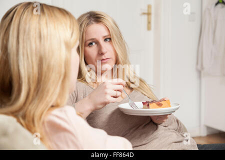 girlfriends in coffee gossip, one looks sad Stock Photo