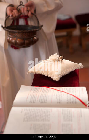 Wedding rings on a white pillow in church Stock Photo