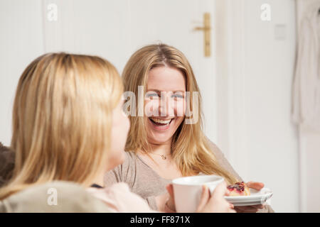 girlfriends in coffee gossip, one is smiling Stock Photo