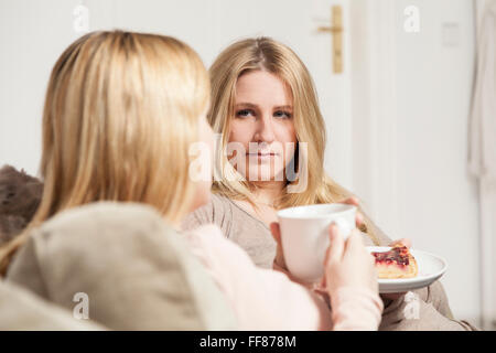 girlfriends in coffee gossip, one is serious listening Stock Photo