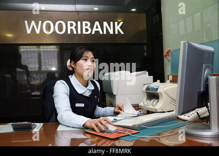 Kaeseong, North Korea. 28th Feb, 2006. Picture taken date is Feb, 2006. North Korean Kim Myung-ok carries out a transaction at a branch of South Korea 's Woori Bank at the Kaesong Industrial Park in the North Korean border city of Kaesong, about 70 km (45 miles) northwest of South Korean capital Seoul, 27 Feb, 2006. North Korea on Thursday ordered a military takeover of a factory park that had been the last major symbol of cooperation with South Korea, calling Seoul's earlier suspension of operations at the jointly run facility as punishment for the North's recent rocket launch a ''dangerous Stock Photo