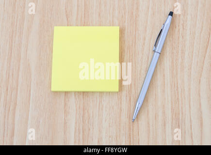 Blank yellow notepad with pen on office wooden table Stock Photo