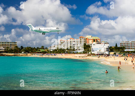 A jet approaches Princess Juliana Airport above onlookers on Maho Beach in Philipsburg, Sint Maarten. Stock Photo