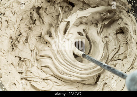 mixing of filler in a bucket with a whisk Stock Photo