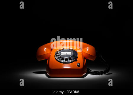 old orange retro phone on black background Stock Photo