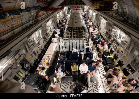 Interior of a U.S Air Forces C-17 cargo plane carrying a modified Airstream trailer for Vice President Joe Biden during a visit to Iraq July 2, 2009.  The Vice President's staff and press corps members sit on seats along the side of the plane. Stock Photo