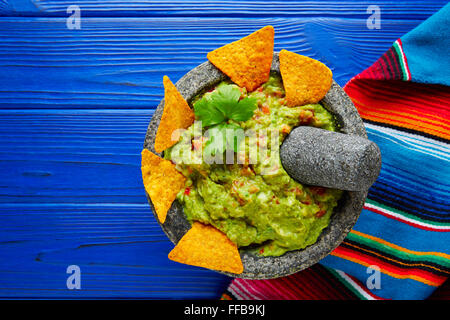 Guacamole with nachos avocado in Mexican molcajete on blue wood table Stock Photo