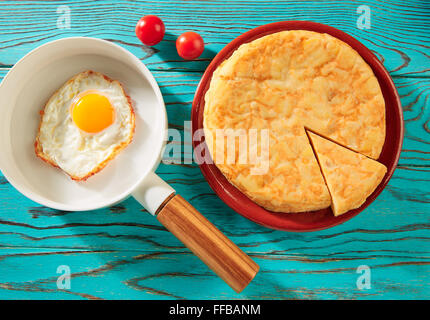 Egg over easy on white pan and potatoes omelette tapas from Spain Stock Photo