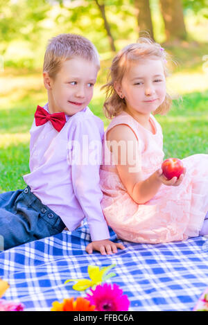 Vertical portrait of a six-year old couple at a picnic in the park Stock Photo