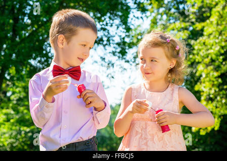 Happy laughing children doing soap bubbles Stock Photo