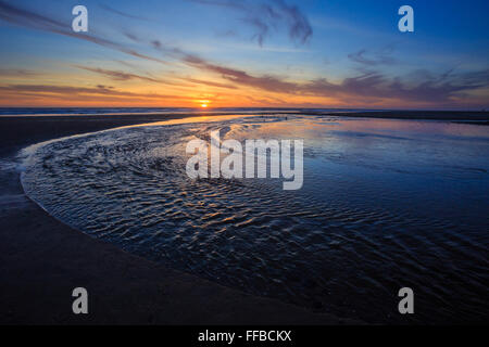Amazing sunset on the D River Beach in Lincoln City Oregon, home of the world's shortest river that flows into the ocean. Stock Photo