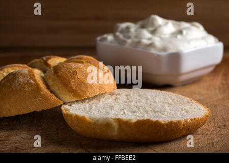 One whole bun with cheese cream in background Stock Photo