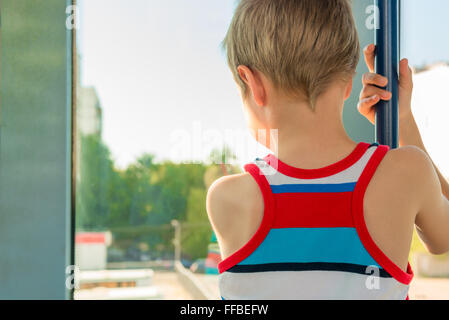 boy in the transport looking out the window and holding the handrail Stock Photo