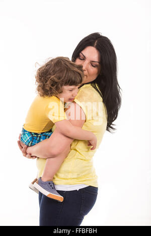 Mother holding crying toddler boy isolated on white background Stock Photo
