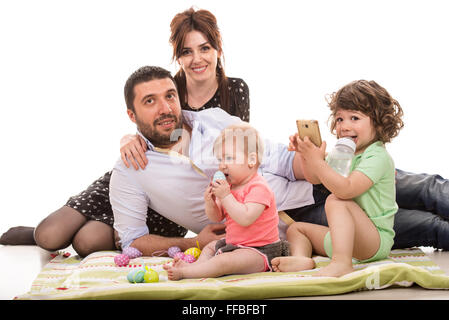 Cheerful family of four members with easter eggs against white background Stock Photo