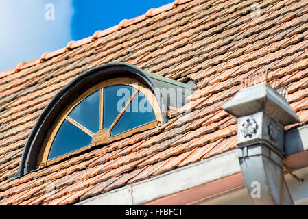 Vintage beautiful window in the attic under the roof of the house Stock Photo