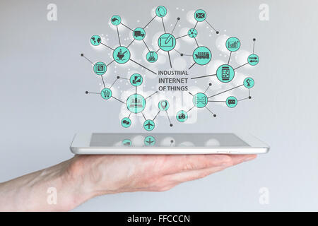 Industrial internet of things IOT concept. Male hand holding modern smart phone or tablet with illustration of connected things Stock Photo