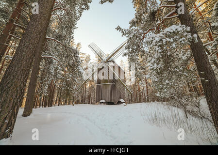 Old wooden windmill in forest in winter Stock Photo