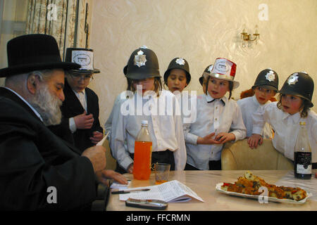 Young Orthodox Jewish boys in fancy dress collecting for their school (Yeshiva) wait in anticipation of the amount they will receive during a visit to the house of Mr Glick, a well off man of the area. Purim is one of the most entertaining Jewish holidays.  It commemorates the time when the Jewish people living in Persia were saved from extermination from a massacre by Haman. Due to the courage of a young Jewish woman called Esther. It is customary to hold carnival-like celebrations on Purim, and for groups of men to go round on the back of lorries and in open top buses visiting local wealthy Stock Photo