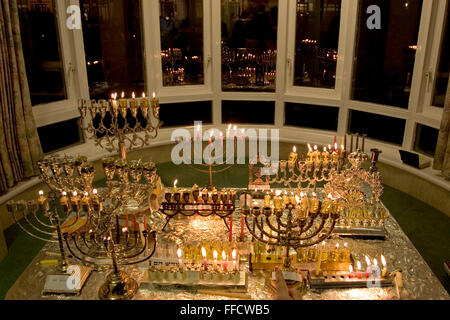 Chanukah last for 8 days and is the Jewish festival of light. It commemorates the rededication of the temple after it had been defiled. A candle is lit every night. In order to bring light to the world some put the candles in their front window.  Here on the 5th day of Chanukah at a local old peoples home each resident has their personal menorah in the window. Stock Photo