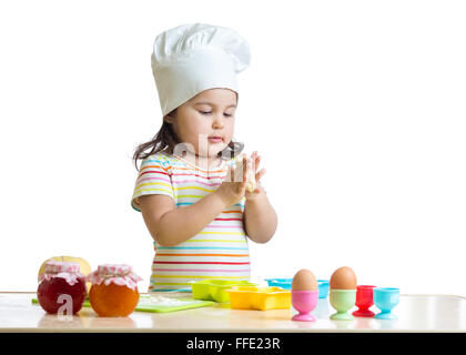 Child little girl kneading the dough for the cookies, isolated on white Stock Photo