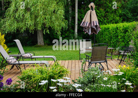 Wooden patio or deck in backyard of a home with outdoor furniture Stock Photo