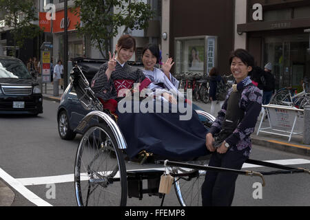 Happy girls, friends, young women smiling, passengers on rickshaw. Tokyo, Japan, Asia Stock Photo