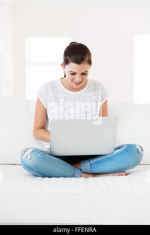 relaxed young girl using laptop in living room at home Stock Photo