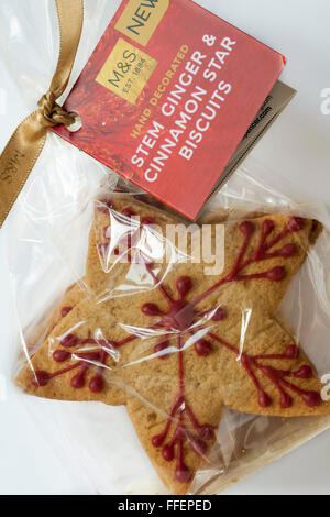 Pack of M&S hand decorated stem ginger & cinnamon star biscuits wrapped in cellophane set on white background Stock Photo