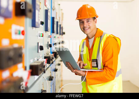 smiling male engineer with laptop computer in control room Stock Photo