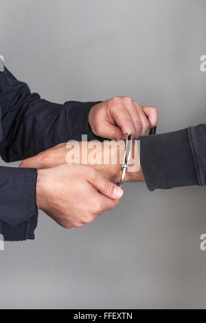 police officer puts handcuffs Stock Photo - Alamy