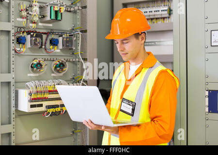 experienced industrial engineer using laptop computer in machine control room Stock Photo