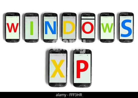 Windows XP written on the screens of smartphones photographed against a white background. Stock Photo